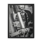 Heavy Equipment Engineering Art Vertical macro photography of a massive excavator hydraulic cylinder and industrial hosing in high-contrast black and white.